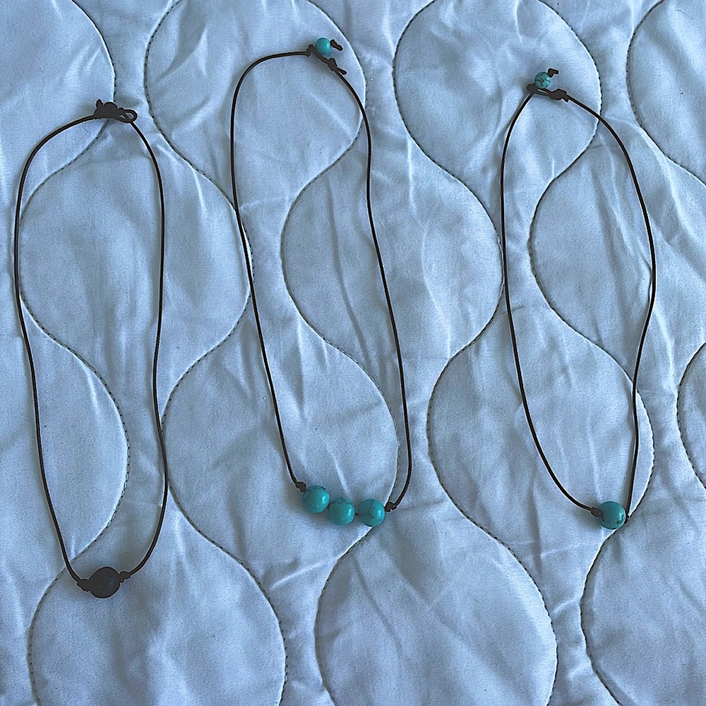 3 necklaces. Black charcoal, teal marble with 3 beads, teal marble with 1 bead